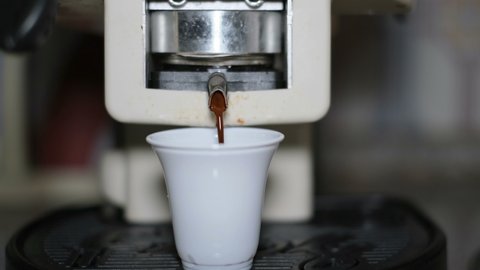 Coffee capsule pods machine making espresso in a plastic cup for morning breakfast, caffeine hot drink