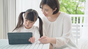 Asian little girl using a tablet PC. Online class concept.