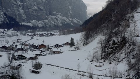 Drone Aerial of Lauterbrunnen surrounded by the Mountain Eiger in the swiss alps. The winter in Switzerland has begun and the ski and holiday season has started. Heavy snow in this resort village.