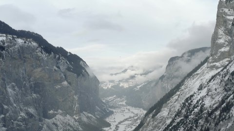 Drone Aerial of Lauterbrunnen surrounded by the Mountain Eiger in the swiss alps. The winter in Switzerland has begun and the ski and holiday season has started. Heavy snow in this resort village.