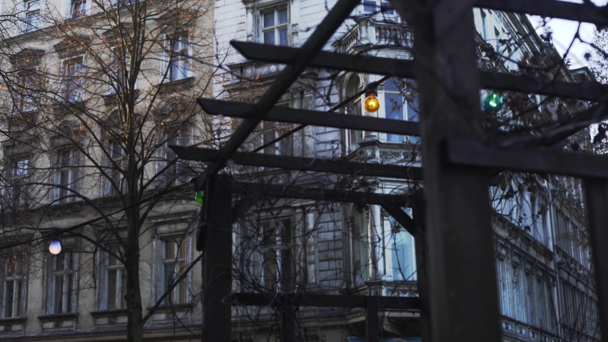 Dolly push towards mysterious looking old building with bow front in Berlin Kreuzberg with wooden structure in the foreground on a winter day during corona pandemic Royalty-Free Stock Footage #1071930067