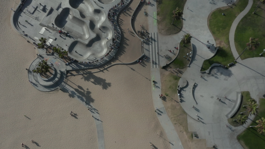 AERIAL birds view flight over Venice Beach skatepark with palm trees and beautiful shadows, Sunny, Los Angeles California 