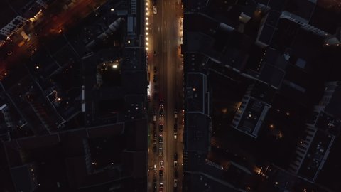 Birds Eye View of City Street at Night and Top View of Rosenthaler Platz Square in Berlin, Germany Mitte distict with Glowing Street lights and car traffic, Aerial Overhead Shot