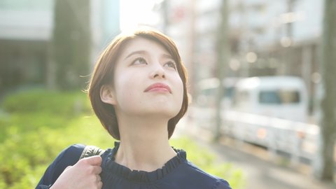 Young asian woman looking up to sky.