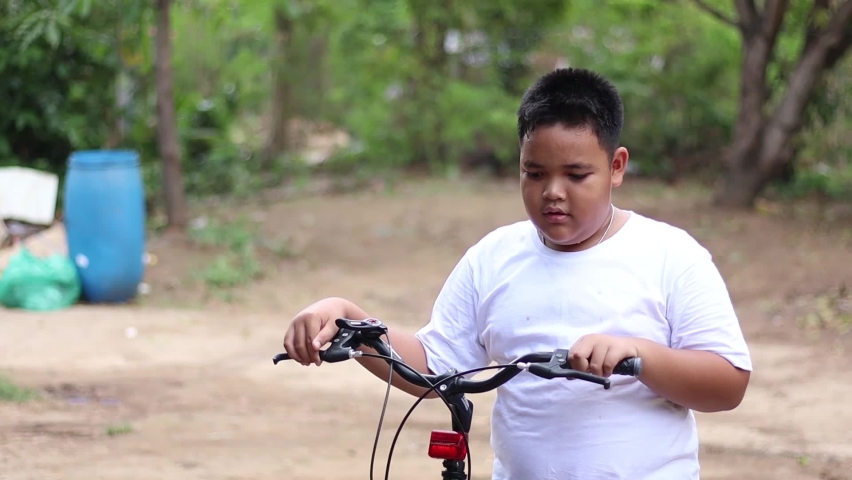 Asian boys exercise bicycles for health On holidays, during the coronavirus outbreak, the sun sets in the summer. | Shutterstock HD Video #1071949786