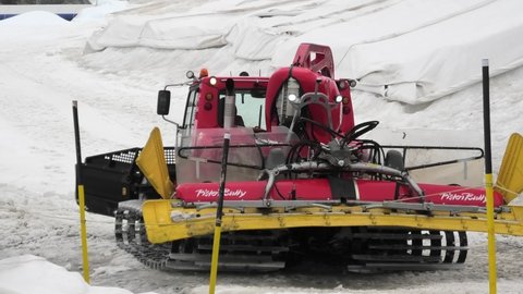 Titlis, Engelberg, Switzerland - Aug 27, 2020: close up of a big snow cat in summer on top of cable car station of Titlis peak in the snow. Engelberg area of Switzerland