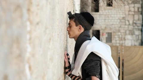 A boy meets his peaceful inner self, he is laying the phylacteries (a Jewish ritual). an awe inspiring prayer at the Wailing Wall, January 8th, 2019, Jerusalem, Israel.