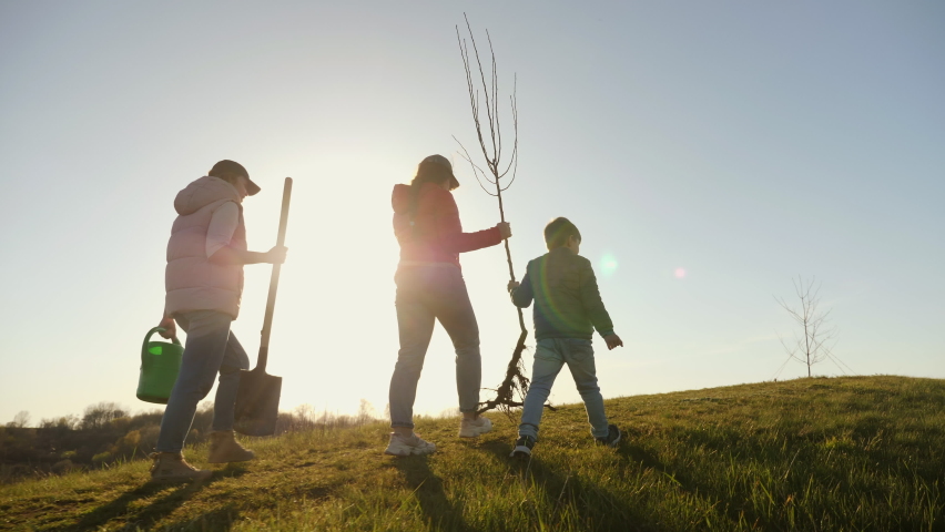 Mom with two children going to plant a tree Royalty-Free Stock Footage #1071958972
