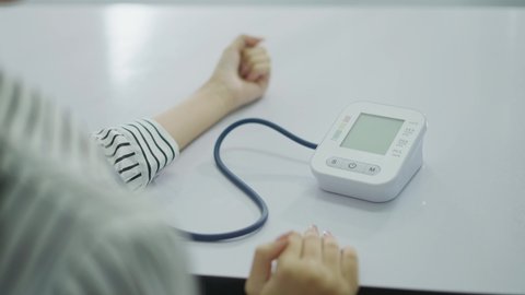 Close-up woman Self monitoring , analysing, check blood pressure. Healthcare equipment, devices at home. Spanish woman measure blood pressure in BP watch device.