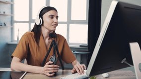 Woman blogger or vlogger streaming online on social media to her subscribers. Woman using microphone and computer for video calll
