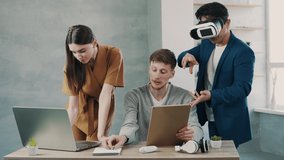 Teamwork in modern office, mans and woman managers look at the computer screen and using virtual reality headset - Powered by Shutterstock - Get 15% off with code: PIKWIZARD15