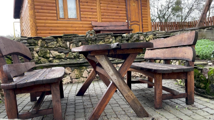 Close up of wooden table with benches in countryside. Log table and benches in empty village in cloudy weather.