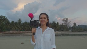 Young attractive woman travel blogger or vlogger recording video movie and looking at camera and talking on video shooting. Social media influencer people or content maker concept in relax at nature