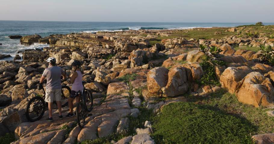 Travel.Tourism. A couple with mountain bikes looking at the sea in the Mkambati Nature reserve, Eastern Cape, South Africa