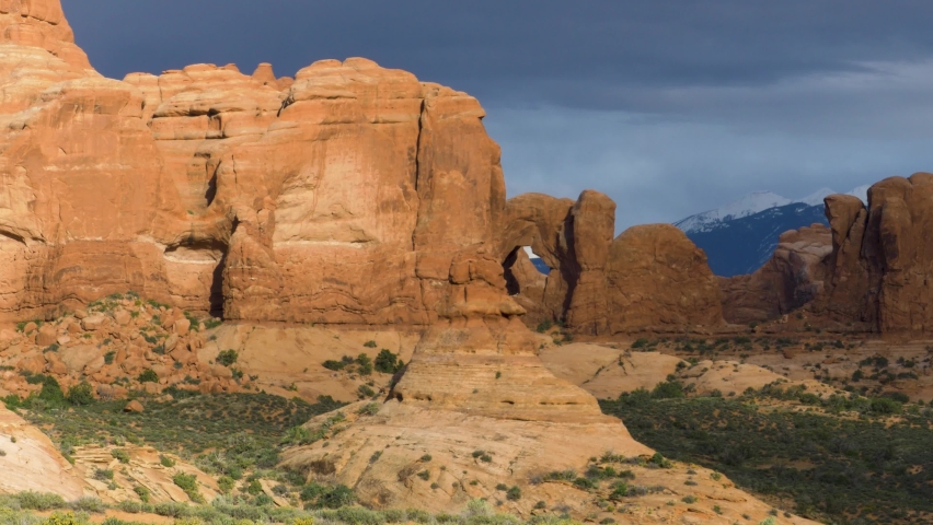 Time lapse of rock formation with natural arch as clouds pass