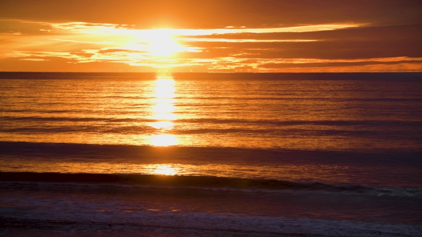Time lapse of beautiful sun rising over the ocean reflecting off water 