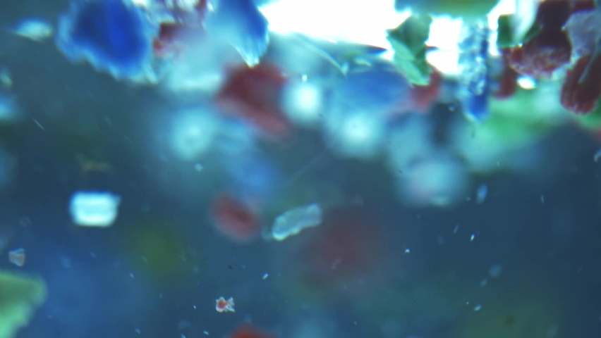 Global ocean pollution - microplastic in water. recycling concept plastic background. plastic fragments or particles in ocean. sing use plastics | Shutterstock HD Video #1071979444
