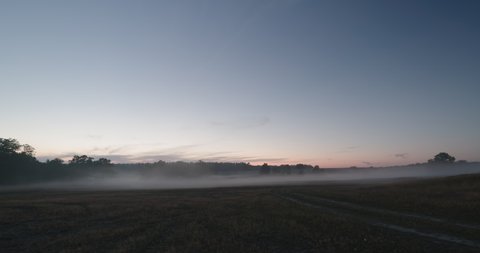 Fog moving over fields in dusk