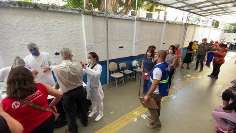 Sao Paulo, SP, Brazil - May 6, 2021: A nurse gives a shot of Pfizer-BioNTech COVID-19 vaccine to a man, left, during a priority vaccination program for people with more than 60 years old.