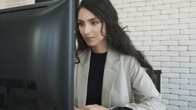 Smart businesswoman using computer and looking at camera then arm crossed up in office.