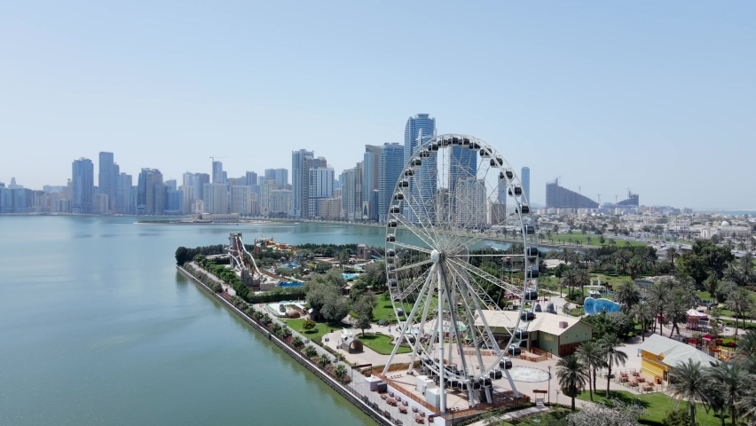 4K: Aerial view of Sharjah's Khalid Lake with city skyline and Eye of Emirates on a bright sunny day, United Arab Emirates Royalty-Free Stock Footage #1071994792