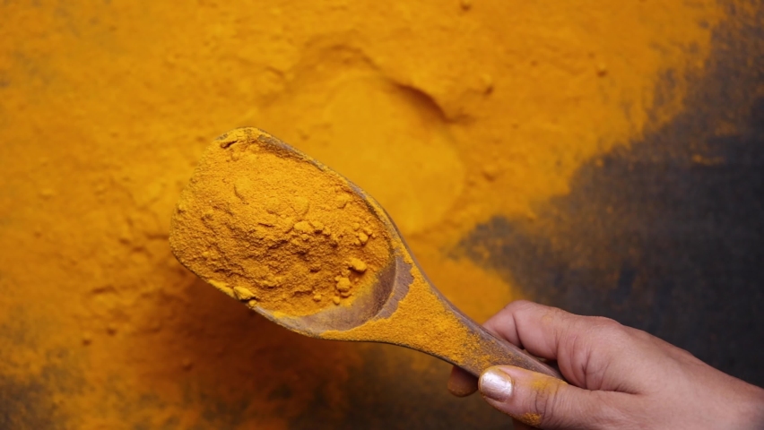 Indian spices turmeric powder in wooden spoon falling on black background, Kerala India Sri Lanka traditional Indian curry masala 4K slow motion video footage, antiseptic antiviral Ayurvedic medicine. Royalty-Free Stock Footage #1071997360