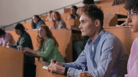 Group of students learns at lecture room. Young people study in university or pupil sitting at school lesson. Teen listens to teacher and writes at auditorium. Modern education indoors of college hall - Powered by Shutterstock - Get 15% off with code: PIKWIZARD15