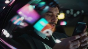 Happy Handsome Businessman in a Suit Commuting from Office in a Backseat of His Car at Night. Entrepreneur Using Smartphone while in Transfer Taxi in Urban City Street with Working Neon Signs. - Powered by Shutterstock - Get 15% off with code: PIKWIZARD15