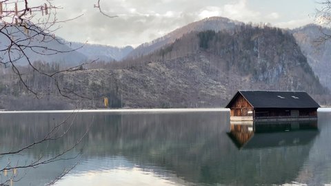 A boathouse at clear alpine mountain lake Almsee in Upper Austria during sunset