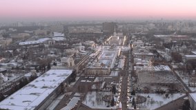 Aerial video: flies over a large city park in Moscow in winter, in the frame of a huge ice rink and beautiful historical buildings