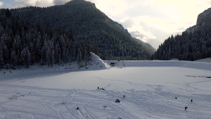 People Sledding on Frozen Tibble Fork Reservoir in American Fork Canyon, Utah - Aerial