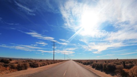 Driving down a lonely, empty road straight through the Mojave Desert - point of view hyper lapse
