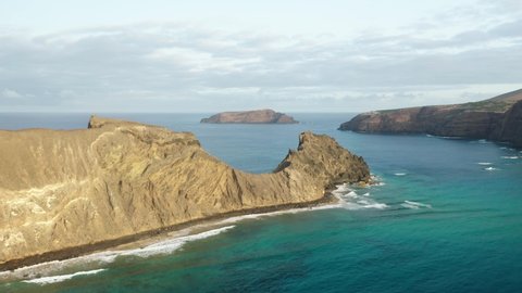 Flying past wild cliffs of Ilhéu da Cal part of Porto Santo in Atlantic Ocean