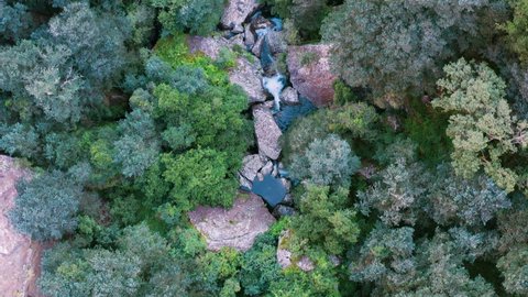 Aerial view of the run off stream of water from Gudu Falls surrounded by a lush green forest in the Drakensberg mountains, KwaZulu-Nata,South Africa