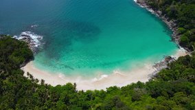 Professional Video 4K. Aerial view shot. Drone camera over white beach sand and sew water clear. Nature video view of beautiful tropical beach and yacht at sea. Freedom beach. At Phuket, Thailand.
