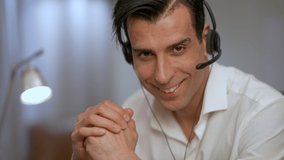 Headshot portrait of handsome confident Middle Eastern man with brown eyes posing in home office. Close-up smiling face of young manager in headphones looking at camera - Powered by Shutterstock - Get 15% off with code: PIKWIZARD15