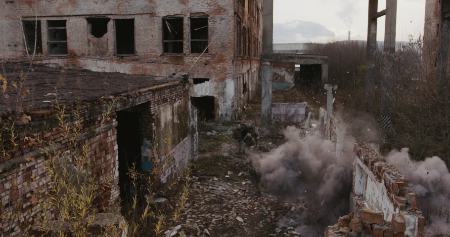 Group of military soldiers rescue the hostage, running past buildings that are bombarded by artillery or a mined area. Concept: war, explosions, acts of terrorism, doctrines. 4k Red 
