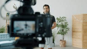 Sports vlogger is recording video with home training jumping with skipping rope and talking to camera smiling enjoying healthy activity. People and vlogging concept.