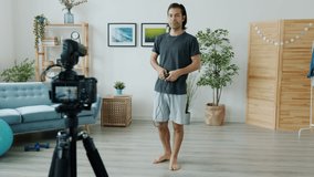 Slow motion of Asian man doing sports skipping on jumping rope and recording video for online blog enjoying creative activity. People and social media concept.