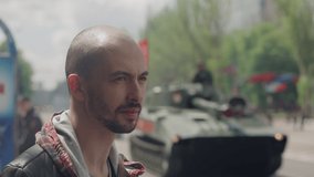 A man watches tanks moving through the city during a military parade - Powered by Shutterstock - Get 15% off with code: PIKWIZARD15