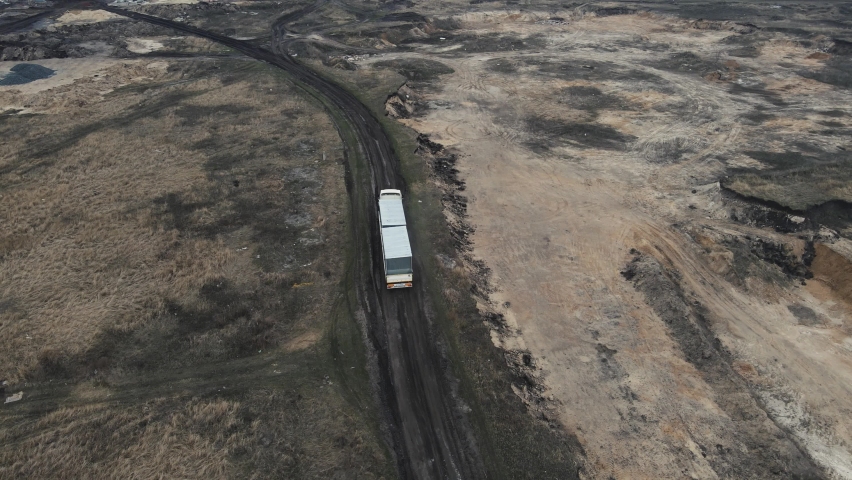 a large wagon is moving along a dirt road. aerial shooting