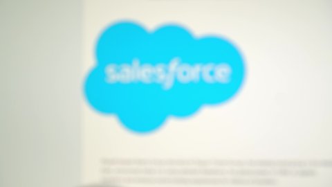 MOGILEV, BELARUS-APRIL 10, 2021: Photo of Salesforce.com homepage on a monitor screen through a magnifying glass. Salesforce.com is a global cloud computing company .