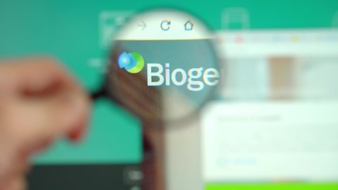 MOGILEV, BELARUS-APRIL 10, 2021: Biogen logo on the home page of the monitor display site through a magnifying glass.