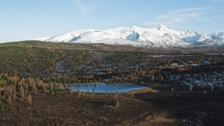Scenic landscape of lake in highland terrain. Breathtaking aerial view of pond located in forest in mountainous area in autumn