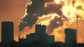 Sun shining through clouds of industrial smoke from power plant smokestacks in city at sunset. Zoom in. 4K UHD Timelapse. - Powered by Shutterstock - Get 15% off with code: PIKWIZARD15