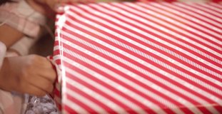 Child Unwrapping Present Close Up. High quality video footage