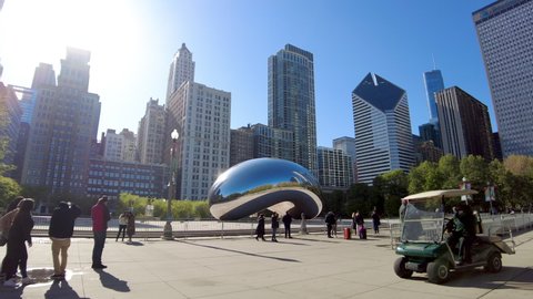 Chicago IL USA - May 6 2021: Smooth gimbal POV shot walking past The Bean in Millennium Park. Visitors must take photos from behind a temporary fence during COVID restrictions