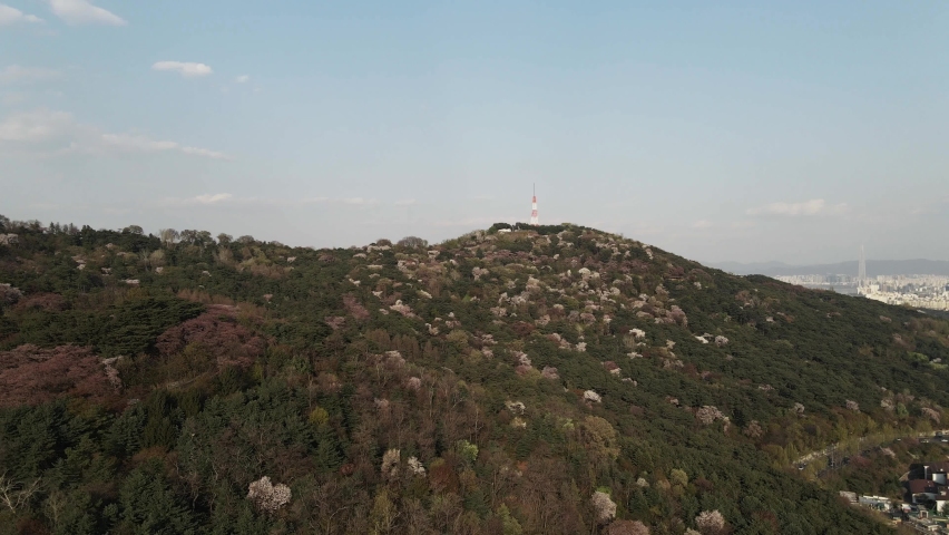Aerial drone Nam mountain with Seoul Tower in foreground and city in background, South Korea