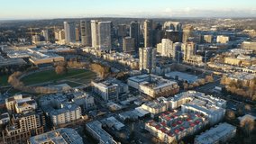 Cinematic aerial drone footage of the city center of Bellevue with Downtown Park and Bellevue Square, skyscrapers, tall office and apartment buildings, blue hour after sunset near Seattle, Washington