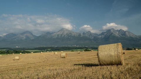 Timelapse of High Tatras in Slovakia,ing clouds and straw bales on field, cinematic view